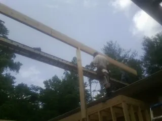 Carpenter setting a ridge beam over a new addition frame — Ice Dam Removal by Roofing Brothers in Grand Rapids