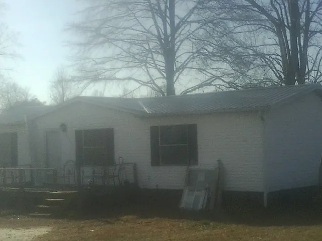 New metal roof on a white painted brick home on a foggy morning in Grand Rapids