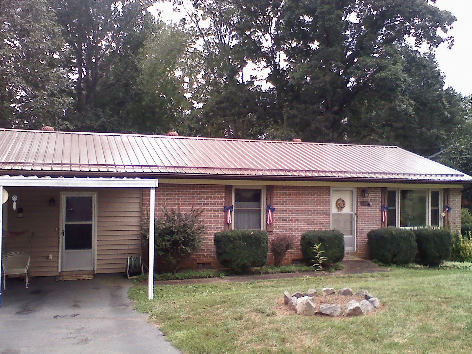 Bronze metal roof and carport on a brick ranch home — Roof Repair work by our crew in Grand Rapids